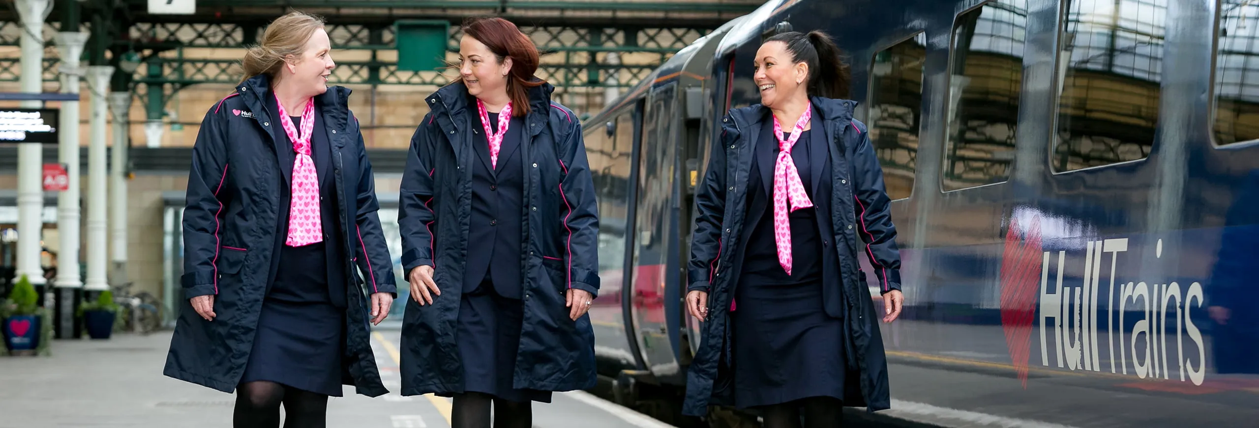 Three Hull Trains onboard crew members walking on the platform