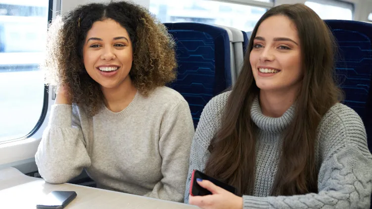 friends smiling together on board a train
